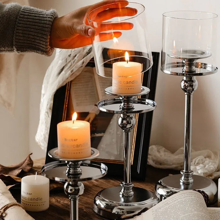 Elegantti metallinen kynttilänjalka lasisella pidikkeellä tunnelmalliseen sisustukseen