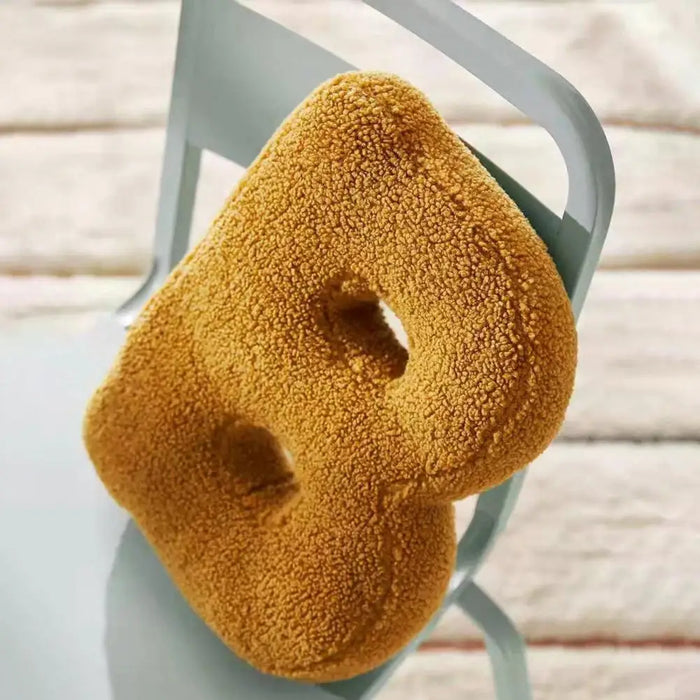 Dekorativ alfabetpude med fløjlsstruktur til boligindretning